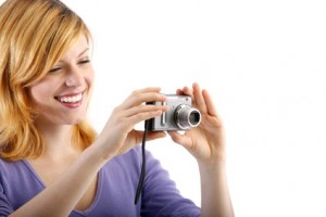 young beautiful woman with a camera (white background)