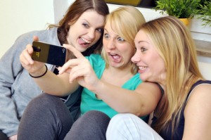 Freundinnen fotografieren sich mit Smartphone