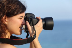 Attractive woman taking a photograph with her camera
